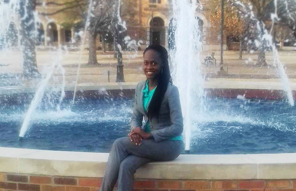 Woman sitting next to fountain of water